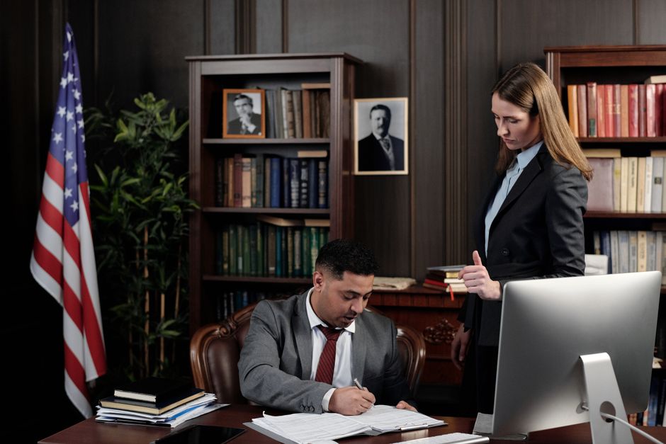 A legal professional reviewing compliance documents in a professional office setting A legal professional reviewing compliance documents in a professional office setting